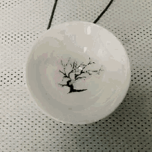 a small white bowl with a tree in it