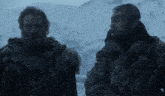 two men are standing in the snow and one has a beard