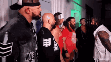 a group of men standing next to each other with one wearing a shirt that says og on it