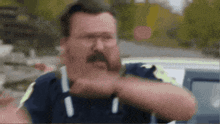 a man with a mustache and glasses is wearing a blue shirt with the number 1 on it