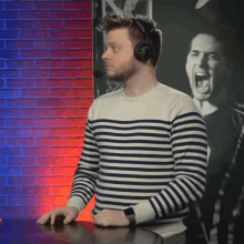 a man wearing headphones and a striped sweater