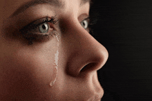 a woman is crying with a tear running down her face