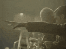 a man is screaming in a crowd of people in a dark room