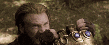 a man with a beard is holding a glove with a blue stone in it .