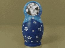 a blue green and orange russian nesting doll with a picture inside