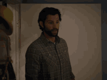 a man with a beard wearing a plaid shirt