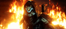 a futuristic soldier is standing in front of a fire with a flame behind him