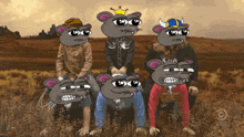 a group of cartoon mice are posing for a picture in a field with a watermark that says comedy central