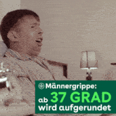 a man is blowing his nose in front of a sign that says männergrippe