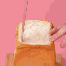 a knife is being used to cut a loaf of bread