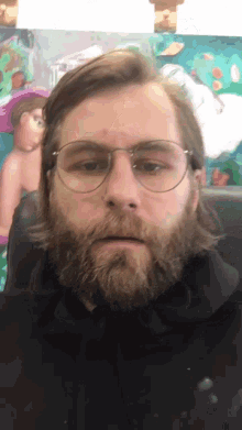 a man with a beard wearing glasses and a black shirt