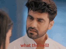 a man with a beard is looking at a woman and says what the hell !