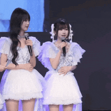 a girl in a white dress holds a microphone