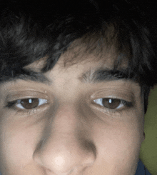 a close up of a young man 's face with a very dark background