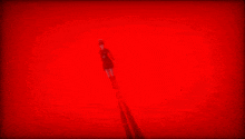 a girl with red eyes is holding a knife in her hand in a red background .