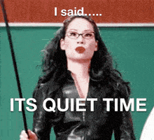 a woman wearing glasses and a leather jacket is holding a stick and says " i said its quiet time "