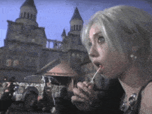 a woman with white hair is eating a lollipop in front of a building