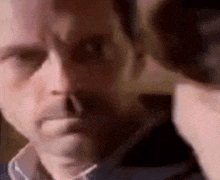 a close up of a man 's face with a woman behind him .
