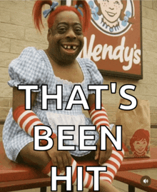 a wendy 's sign is behind a woman in a costume