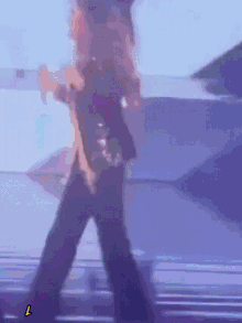 a person is dancing on a stage and the letter l is visible in the corner
