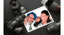 a picture of a man and a woman is surrounded by cameras and lenses