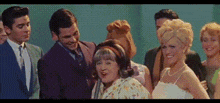 a group of people are standing next to each other and smiling .