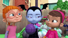 a vampire holding a purple ball with two other girls