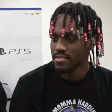 a man with dreadlocks wearing a momma hardin shirt