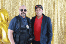 a man in a ping hat stands next to another man in a red shirt