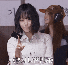 a woman in a white jacket is holding a card in her hand with korean writing on the bottom