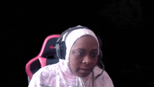 a woman wearing headphones is sitting in a chair .