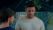 a man and a woman are looking at each other and the man is wearing a white shirt