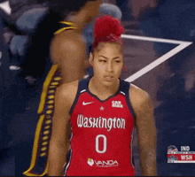 a woman wearing a washington jersey stands on a court