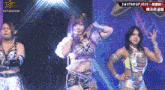three female wrestlers are standing on a stage in front of a screen that says stardom