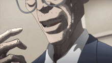 a man with glasses and a suit is smiling