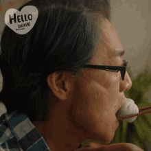 a man with glasses has a hello again sticker on his forehead