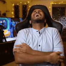 a man is sitting in a chair with his arms crossed and his mouth open