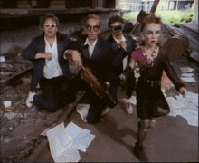 a group of people wearing sunglasses and goggles are kneeling down on the ground