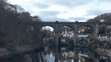 a bridge over a river surrounded by trees and buildings