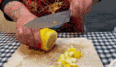 a woman is cutting a lemon on a cutting board with a knife