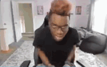 a man is sitting in a chair in a living room playing a video game on a computer .