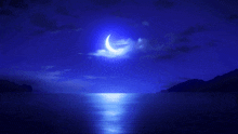 a crescent moon shines brightly over the ocean