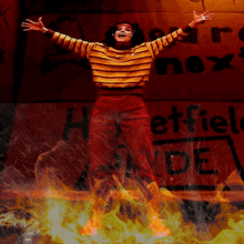 a woman with her arms outstretched stands in front of a sign that says " next "