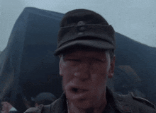 a man in a military uniform is blowing a whistle in front of a tent .
