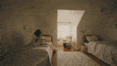a woman sits on a bed in a bedroom between two twin beds