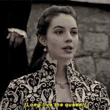 a woman in a black and gold jacket says long live the queen ..