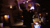 a man in a black shirt is standing in a dark room with a purple light behind him