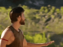 a man with a beard is standing in a field .