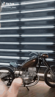 a motorcycle is parked in front of a wall with neon lights behind it