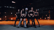 a group of women are dancing together in a dark room